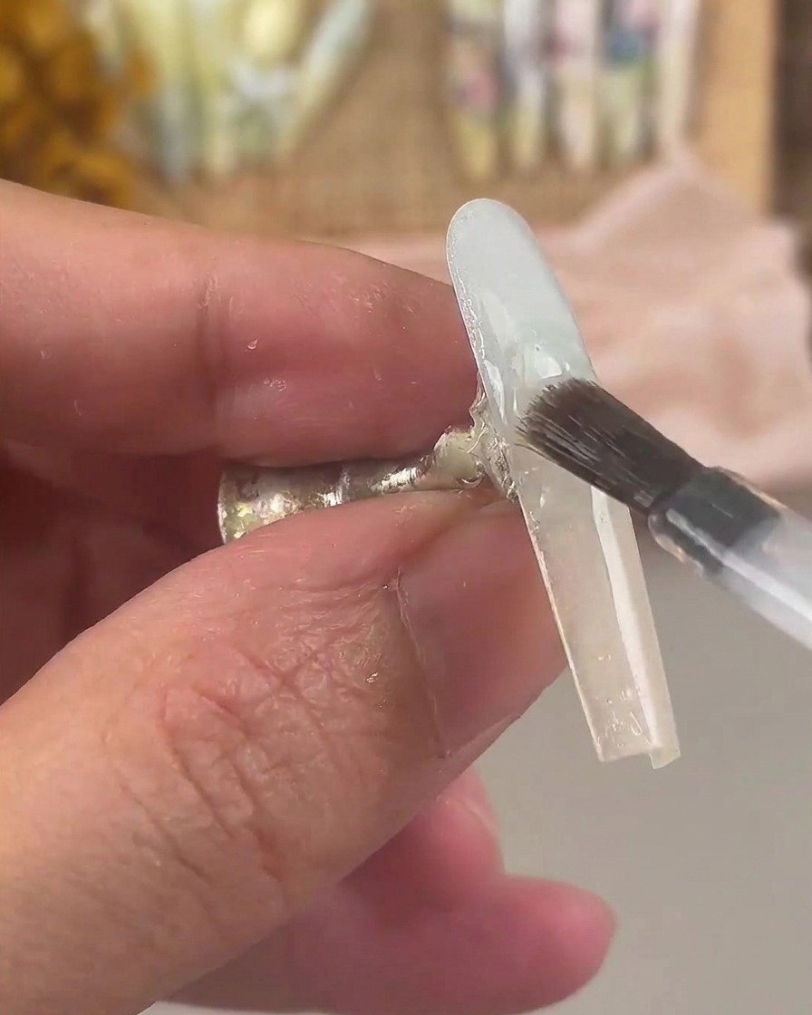 A nail brush coating the gradient-finished nail with a layer of clear base gel.