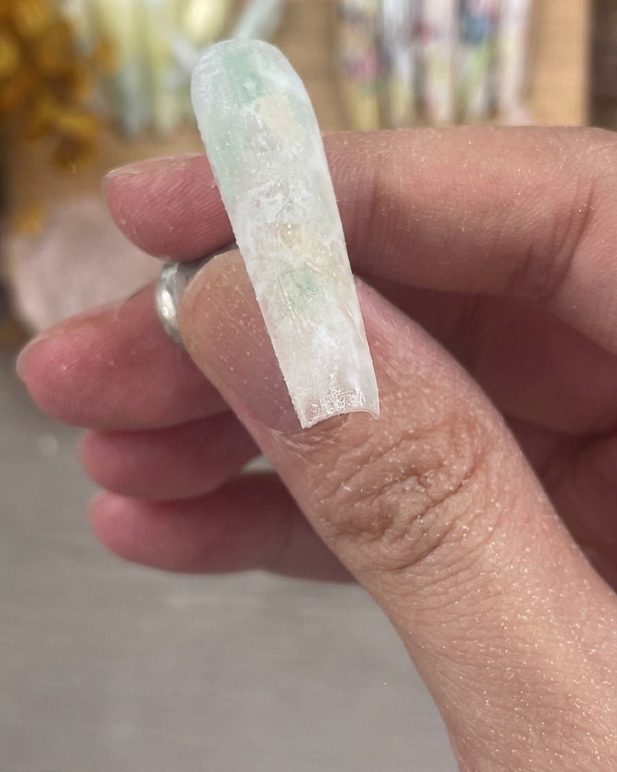 A close-up of a perfectly filed and buffed nail showing a smooth, frosted matte surface.