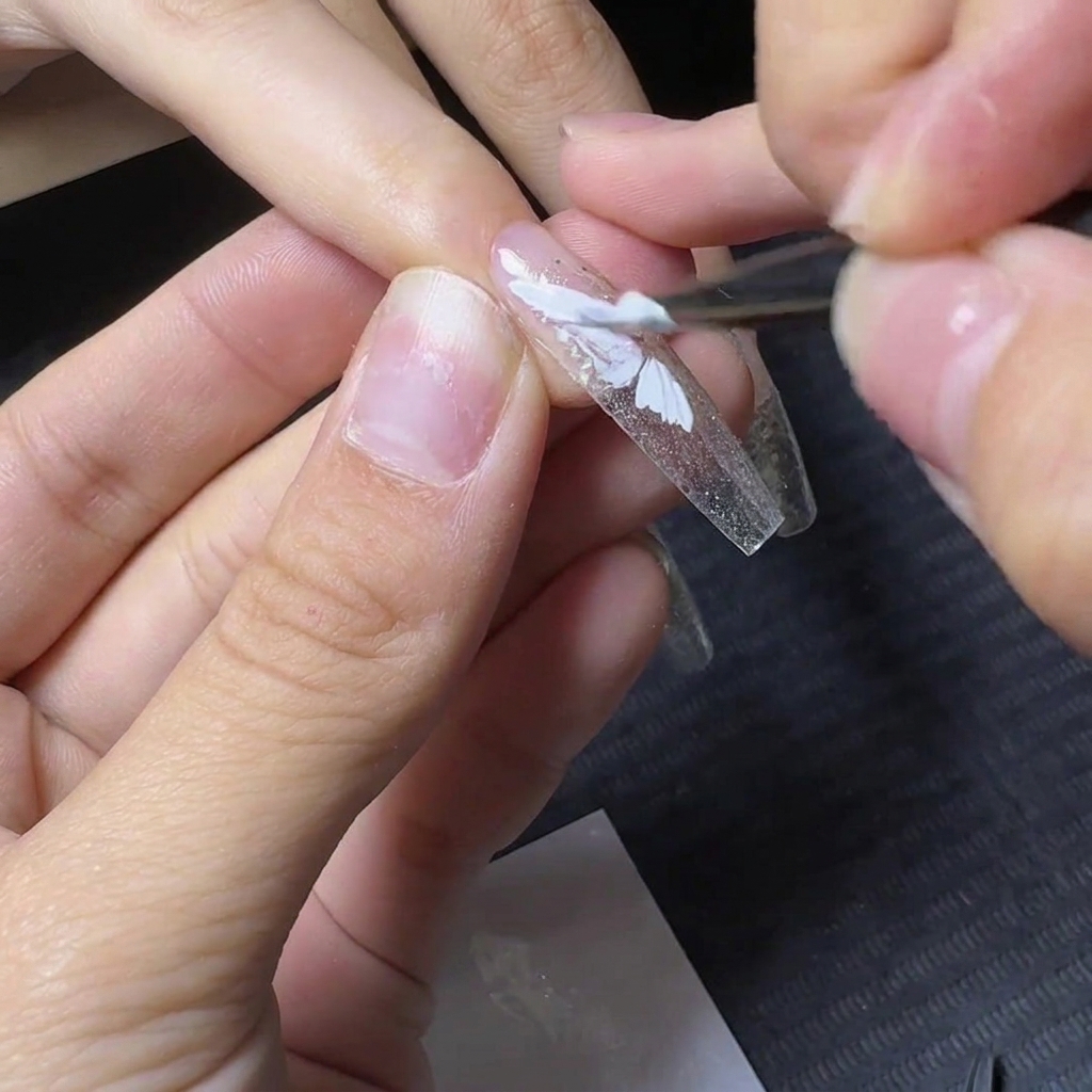 A detail brush filling in the bottom section of the white gel butterfly wing design.