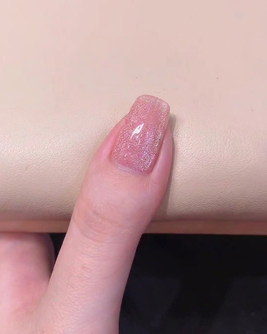 A manicured nail showing dispersed magnetic particles after adjusting the cylindrical magnet to the left side.