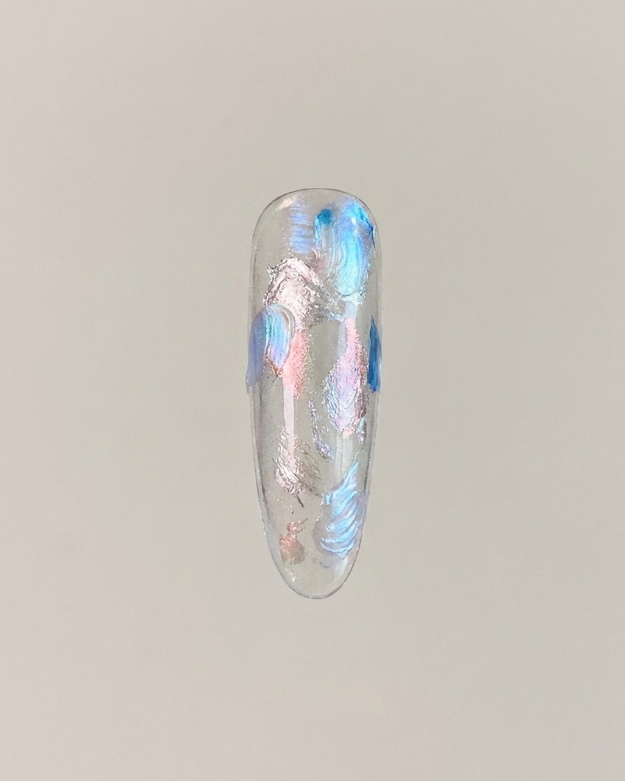 A nail tip displaying cat eye gel magnetized into a glowing center glass ball effect.