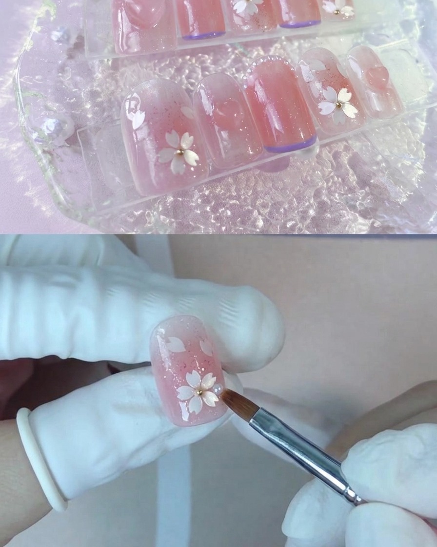 A brush applying a second layer of nude peach gel polish onto a nail.
