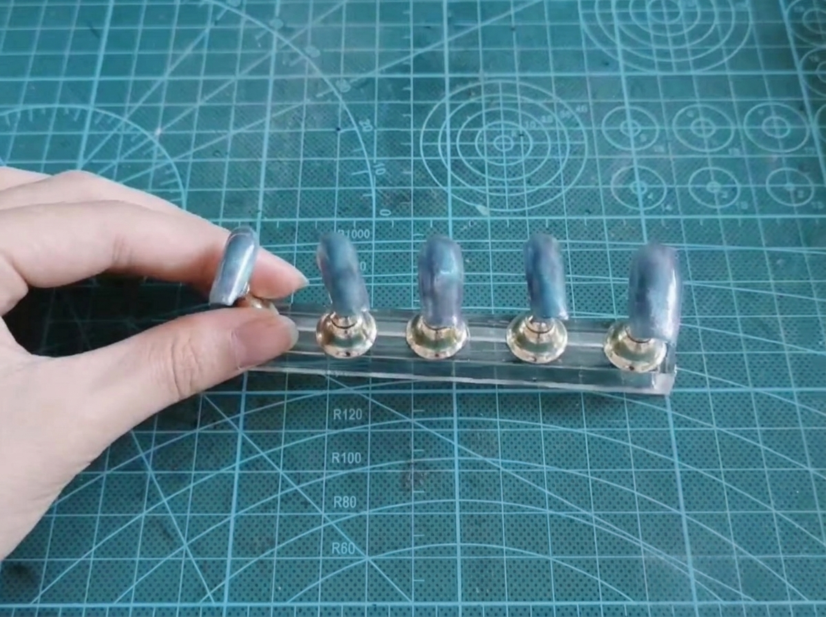 Five nail tips on a display stand showing a finished blue and purple gradient base.