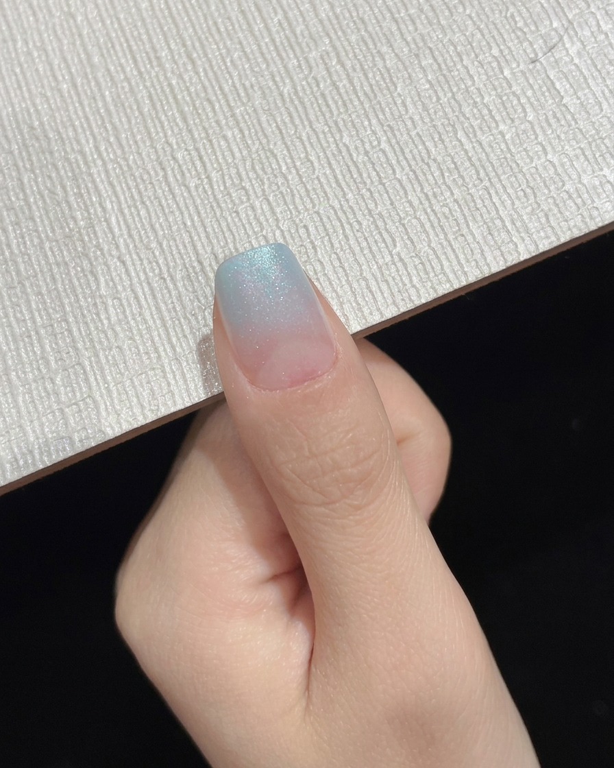 A completed blue gradient ombre nail displayed as an intermediate progress shot.