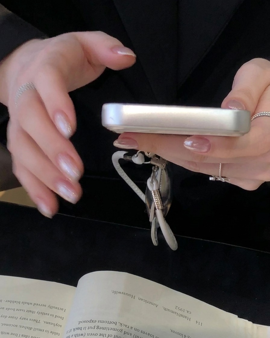 A close-up of a sponge stamp tool depositing ivory white gel onto the cuticle area of a nail.
