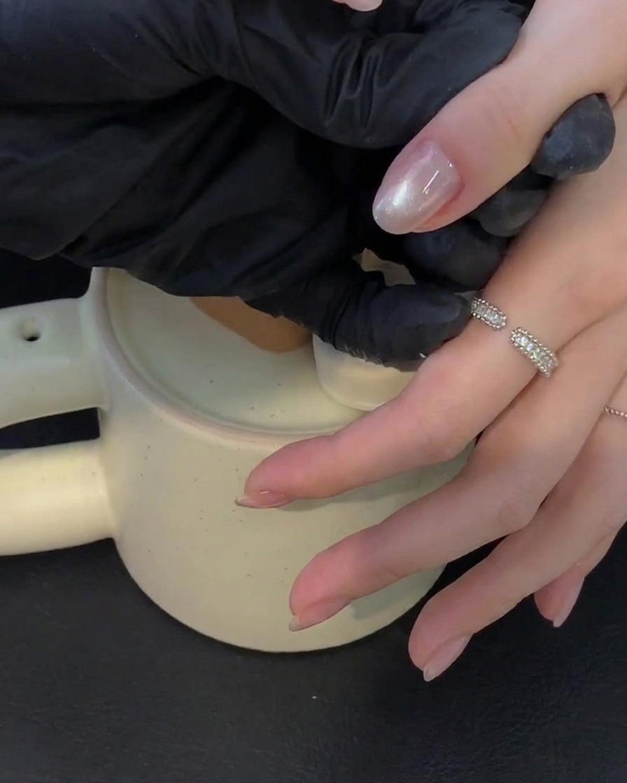 A hand resting inside a UV lamp curing gel nails.