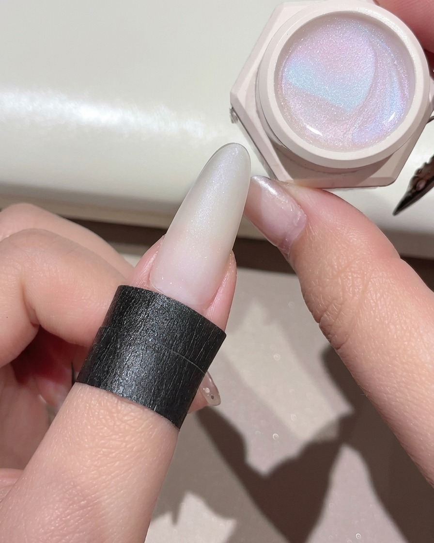 A gel brush applying a shimmering clear cat-eye gel over the prepped nail.
