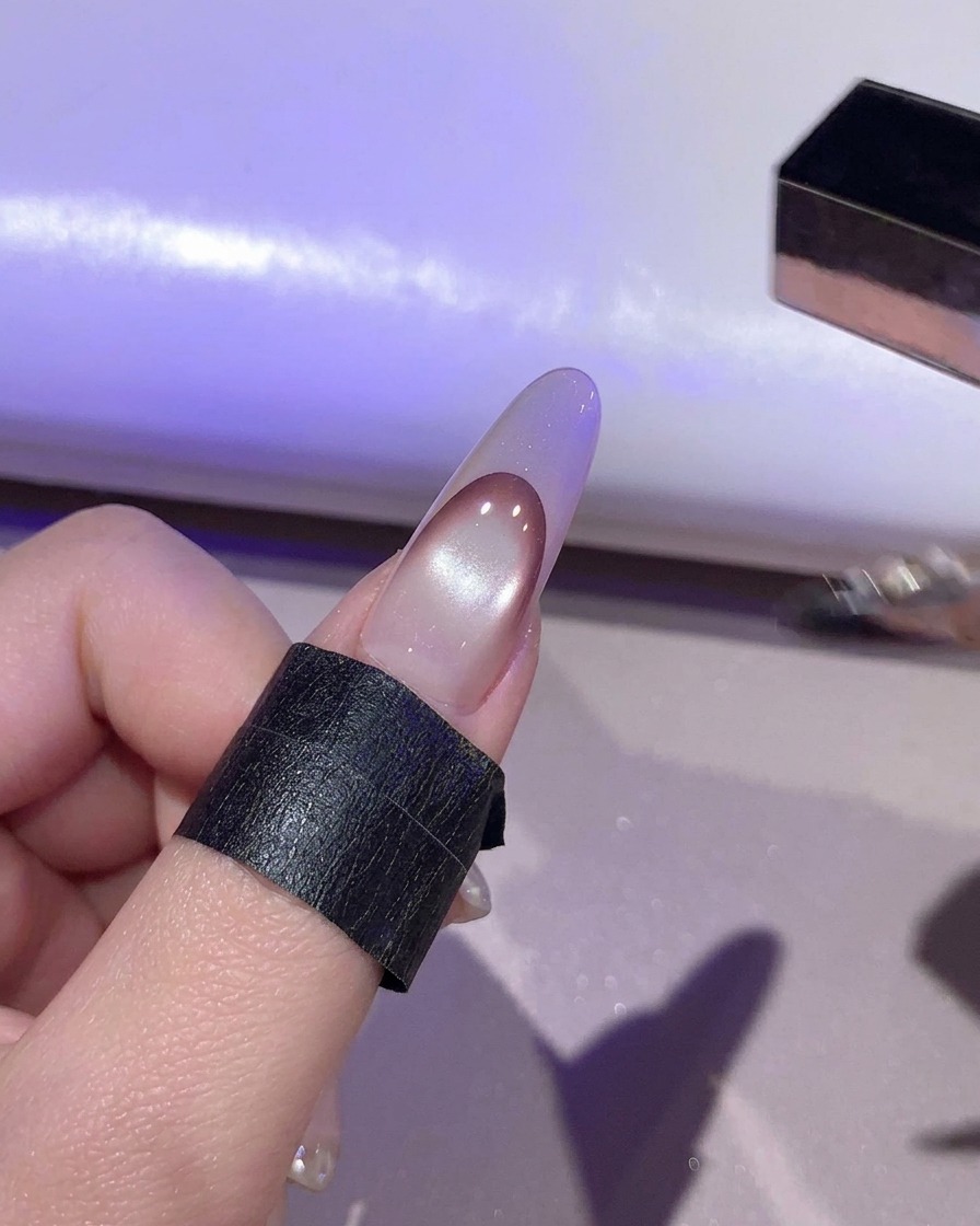 A nail curing under purple light inside a UV/LED lamp.