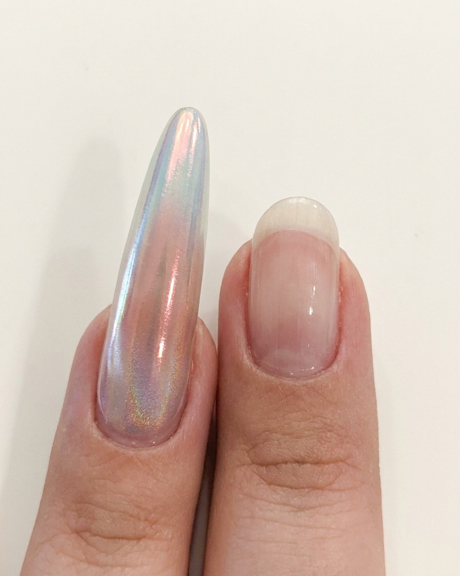 A hand positioned near a UV/LED lamp to cure the nail application.
