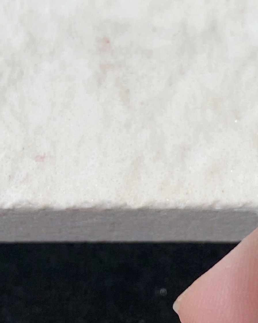 A brush applying clear water-gloss top coat onto a prepped nail surface.