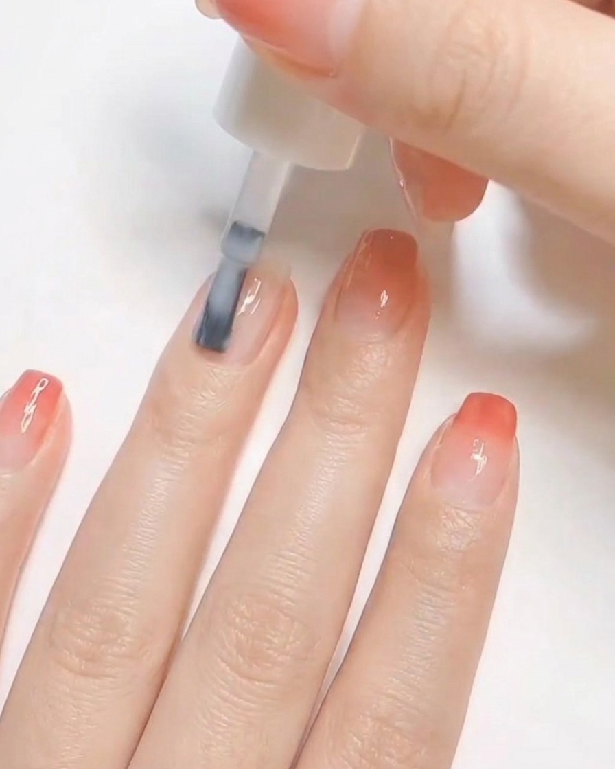 A nail brush applying a coat of opaque white polish to a prepped natural fingernail.