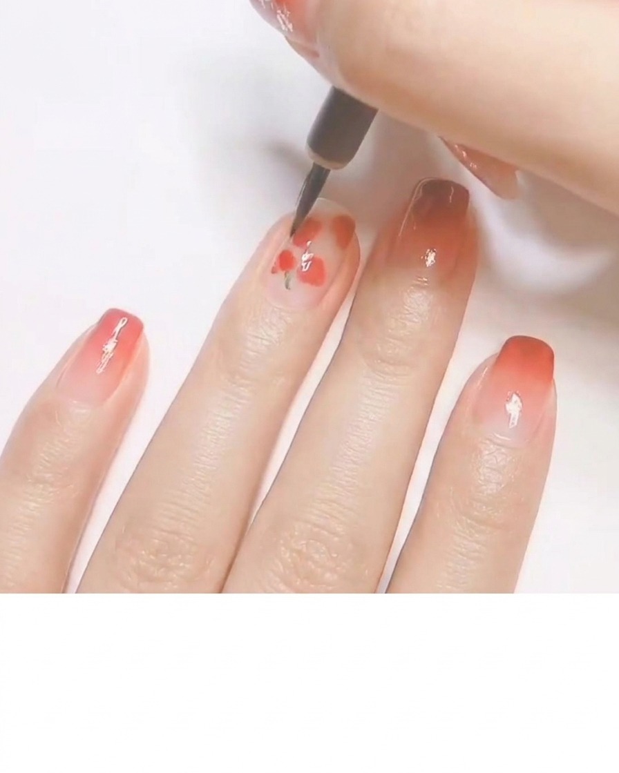 A fine detailing brush adding tiny green leaves and white highlights to small red painted shapes, creating a peach pattern.