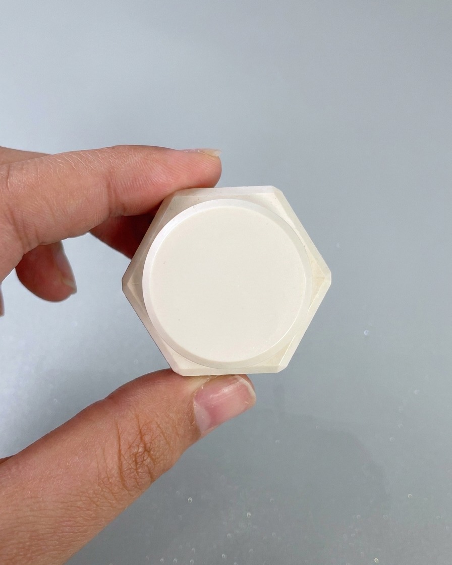 A makeup sponge dabbing white painting gel onto the edges of a painted nail surface.