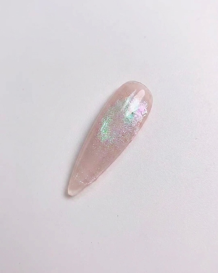 A silicone tool rubbing aurora powder onto a cured nail surface.