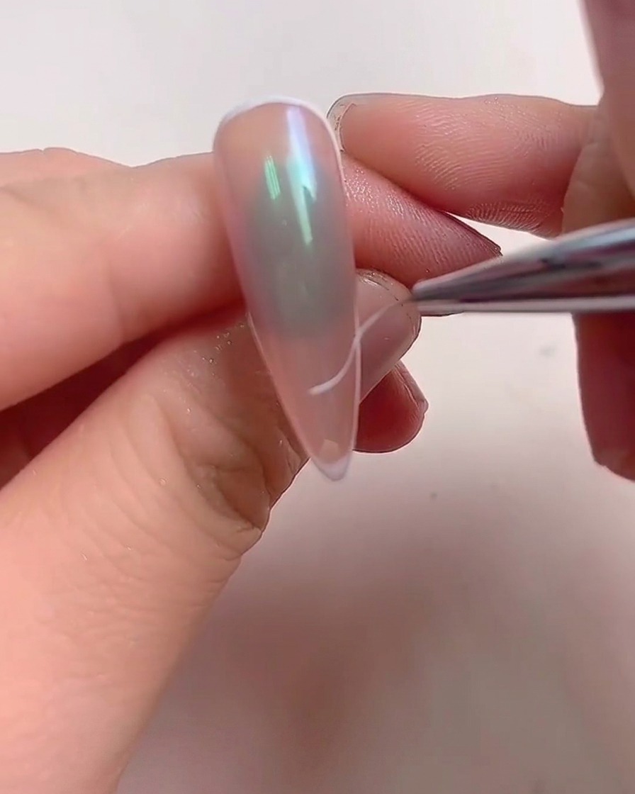 A hand placed inside a professional UV/LED nail lamp with glowing purple light illuminating the fingers.