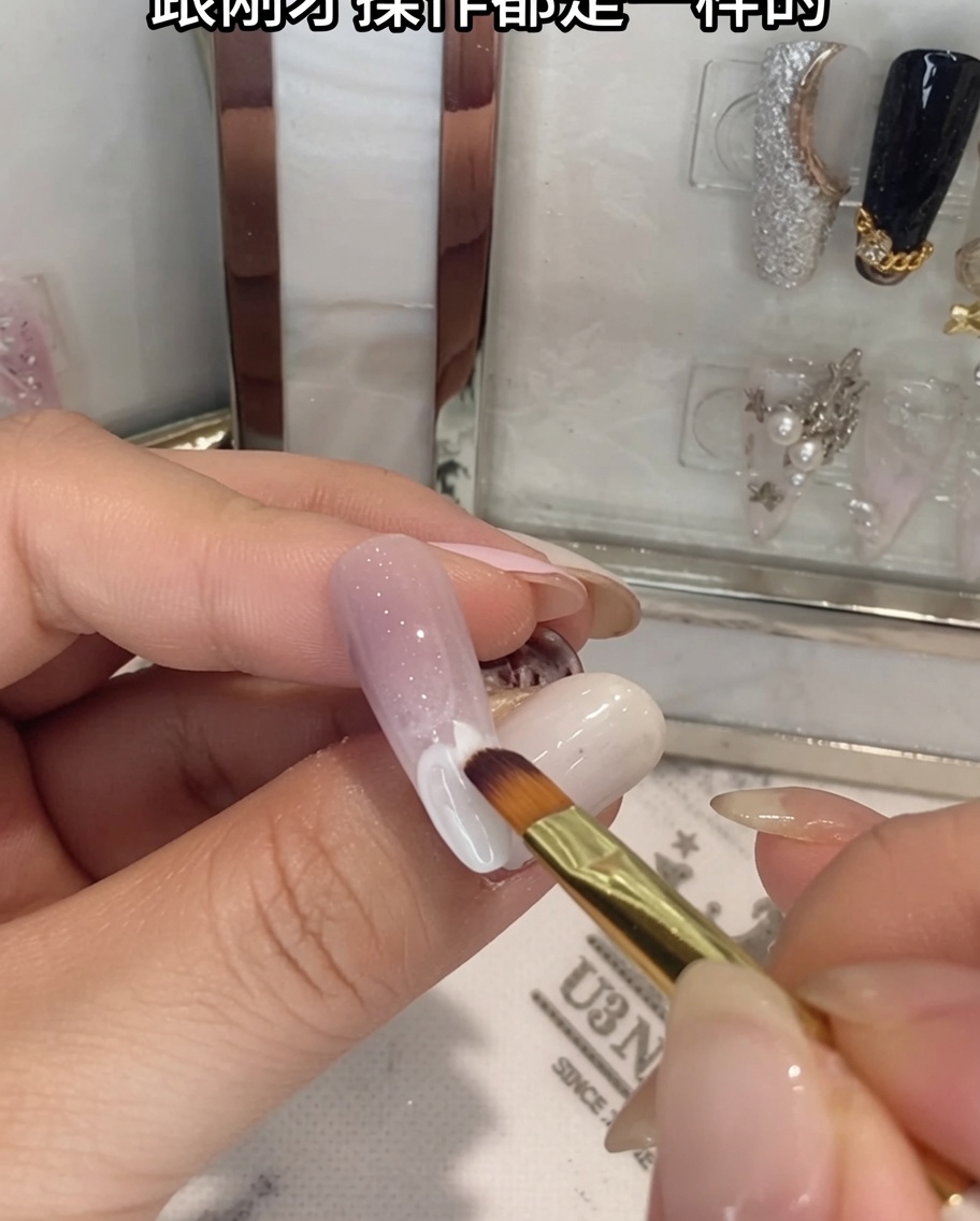 A brush blending white gel onto the lower half of an ombre nail.
