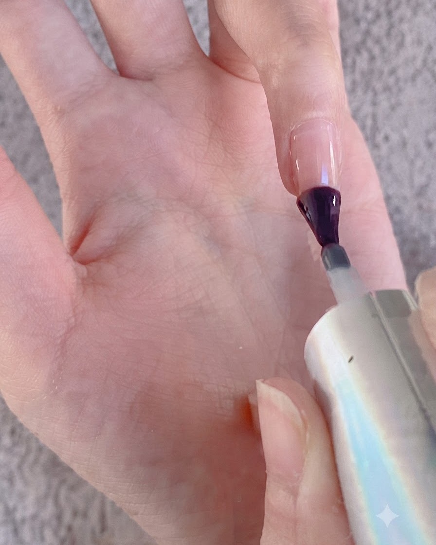 A nail brush applying gel onto a finger surface in preparation for chrome powder.
