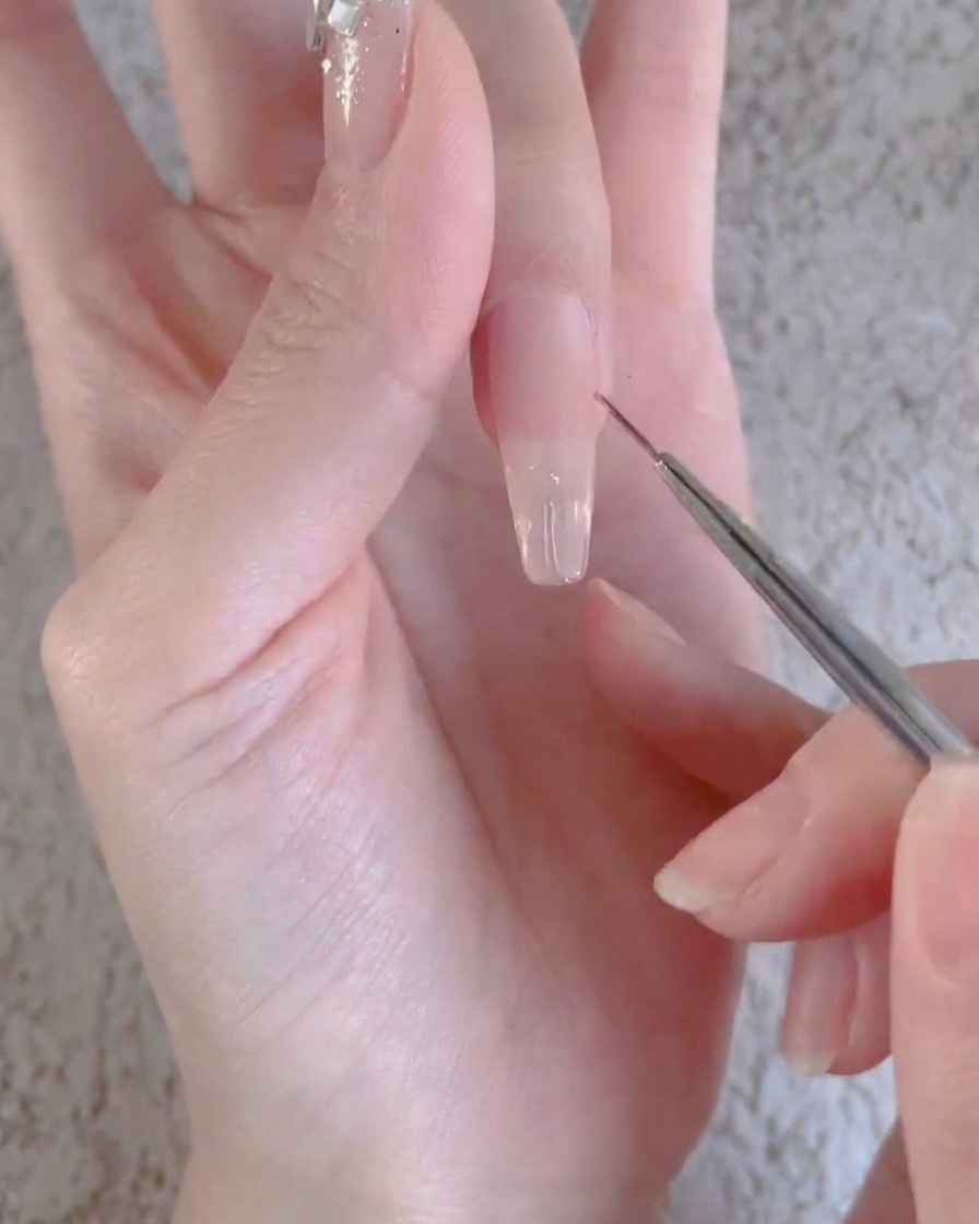 A finger with a clear gel layer being cured underneath a professional UV or LED nail lamp.
