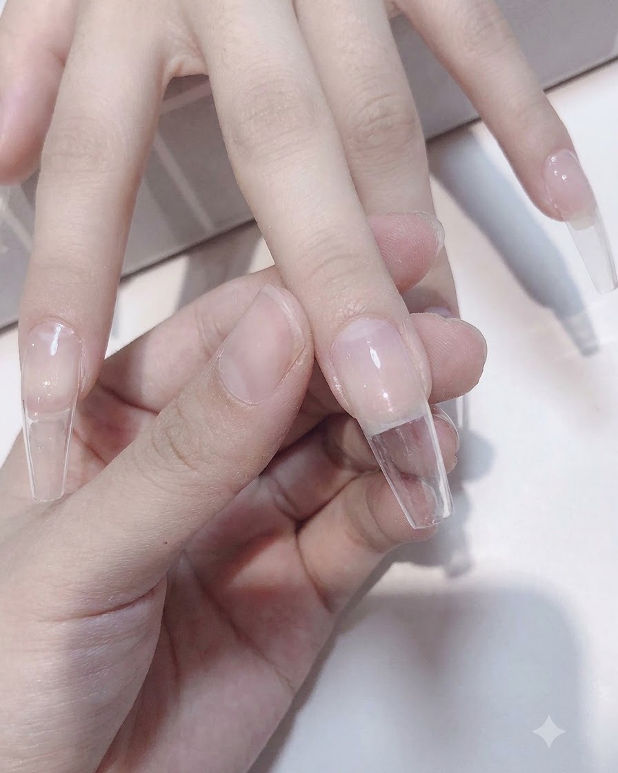 A hand placed under a UV/LED lamp to cure the nail.