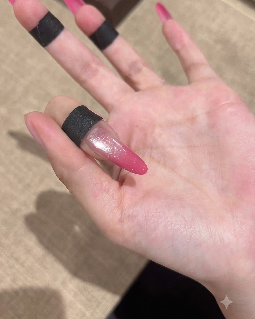 A completed pink gradient cat-eye nail showing a high-gloss finish against a soft background.