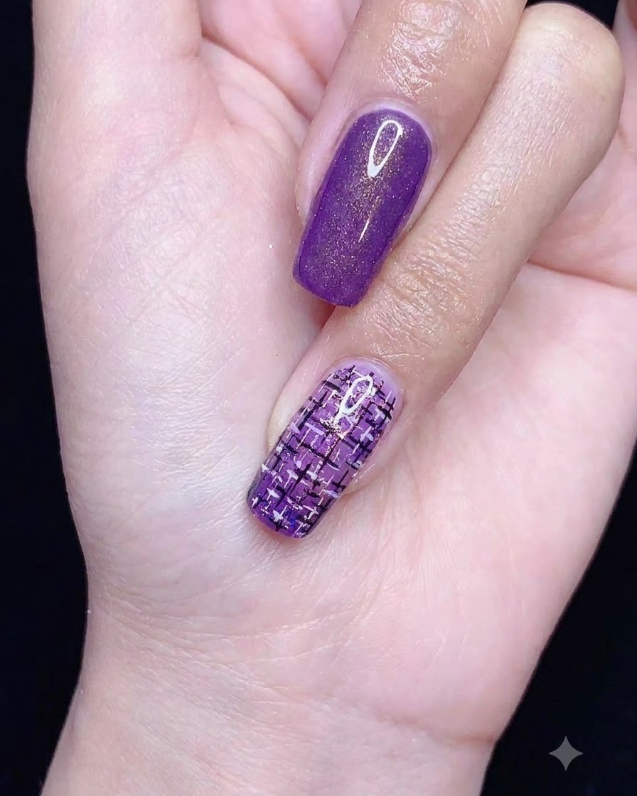 A detailing tool placing small white pearls near the base of a completed tweed nail art design.
