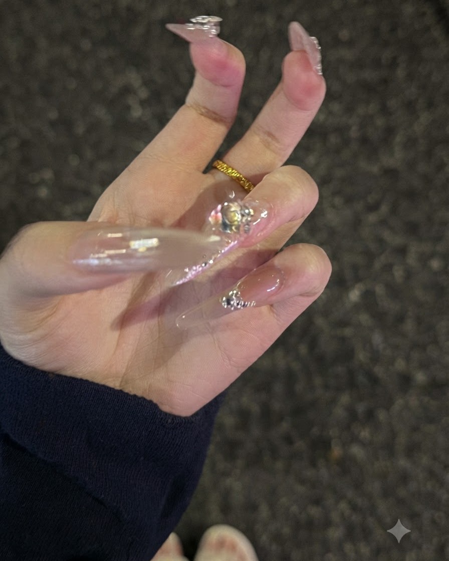 Fingers arranged together in a square configuration to highlight uniform length and 3D crystal charms.