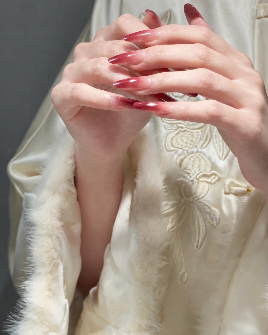 Fingers delicately sliding over each other to demonstrate the smooth texture of finished red gel nails.