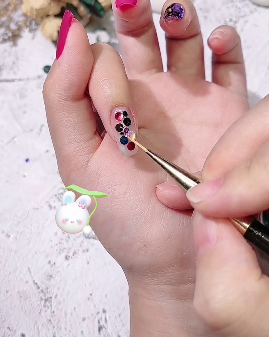 A close-up view of small colored dot sequins being placed into gaps between existing sequins using a detail brush.
