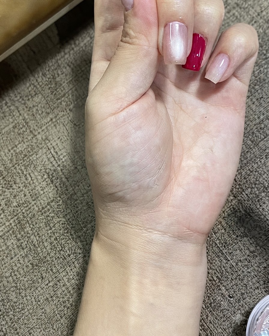 A close-up view of a hand displaying nails treated with magnetic cat eye gel, showing a luminous glowing sphere effect.