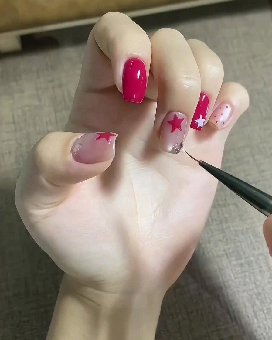 A fine tool placing sparkling crystal gems onto an adhesive gel drop on a decorated fingernail.