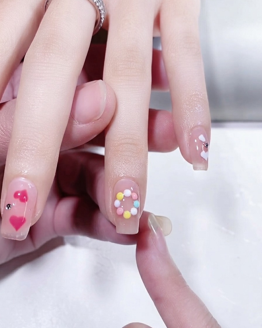 Close-up of a fingernail showing a completed pastel-colored circular ring design.