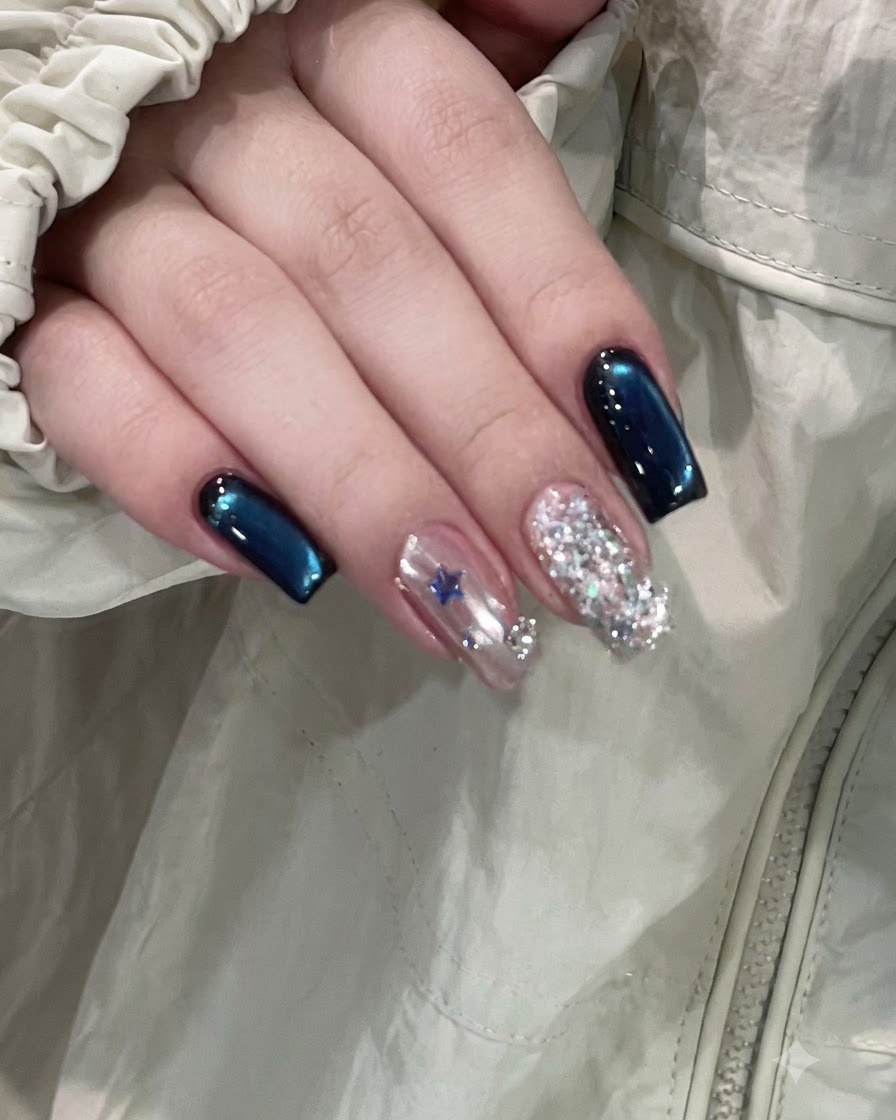 A close-up view of a hand applying top coat to the decorated middle nail before curing.