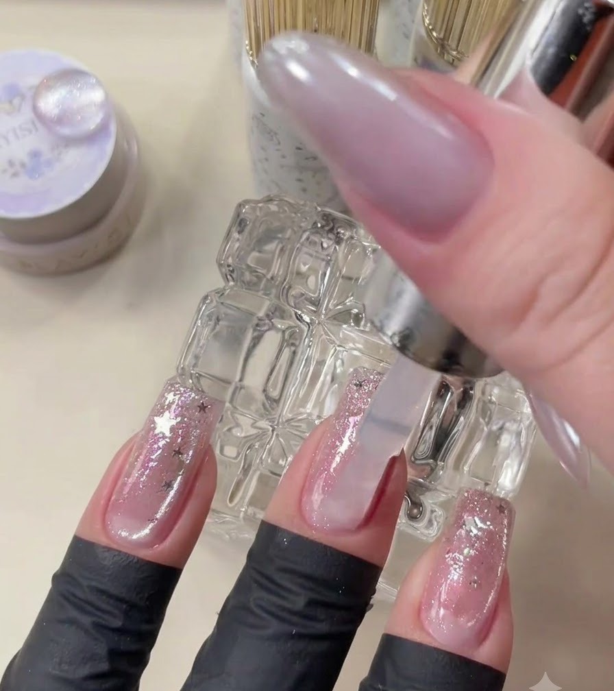 A top coat brush applying clear gel over finished nail art.