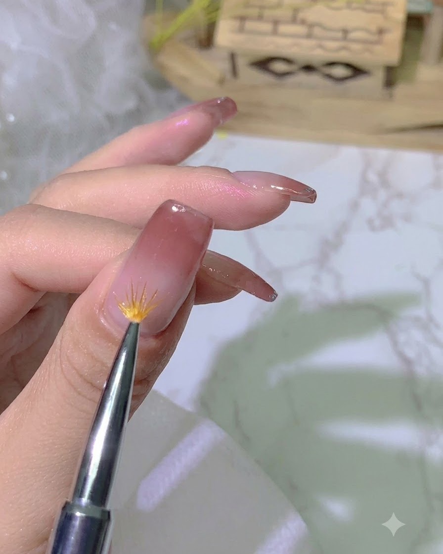 A specialized gradient brush feathering the edge of the gel polish on the nail surface.