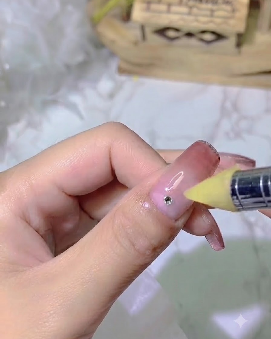 A nail tool applying a precise dot of strong adhesive glue onto a gradient nail.