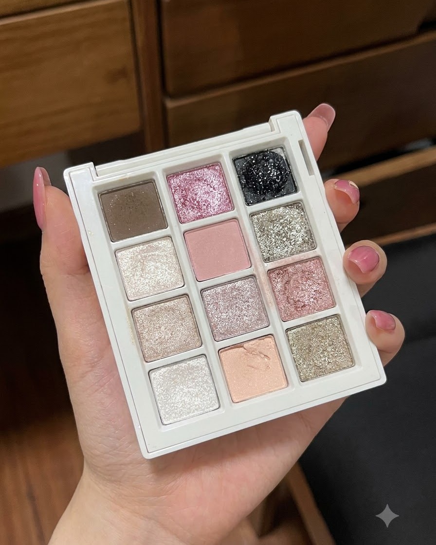 A close-up of a hand holding a multi-well gel palette showcasing various pastel and glitter colors.