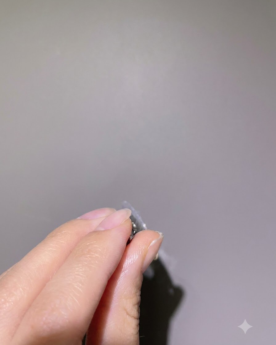 A side profile view of a finger held upside down, allowing the clear builder gel to self-level.