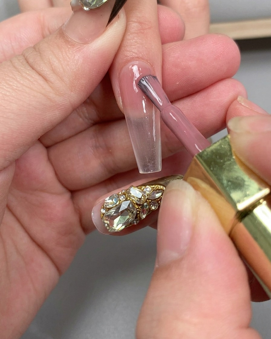 A hand positioned under a UV nail lamp to cure the base coat application.