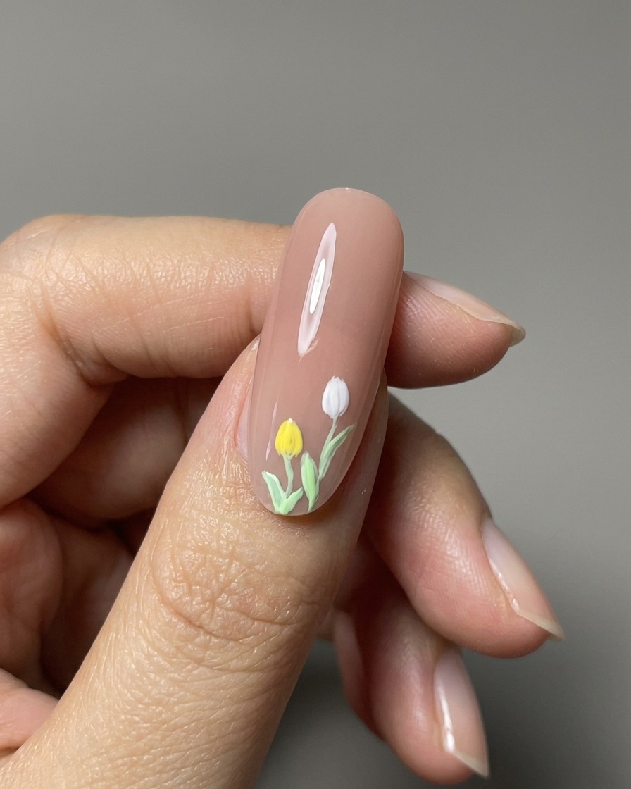 A close-up view of finished 3D painted tulips on a glossy nude nail.