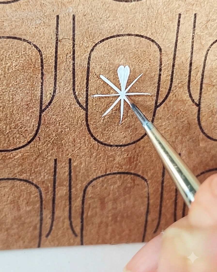 A liner brush adding the second stroke to finish a white petal into a soft teardrop shape.