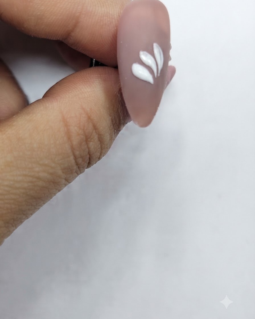 A nail with multiple white petal strokes arranged in a partial circular pattern.