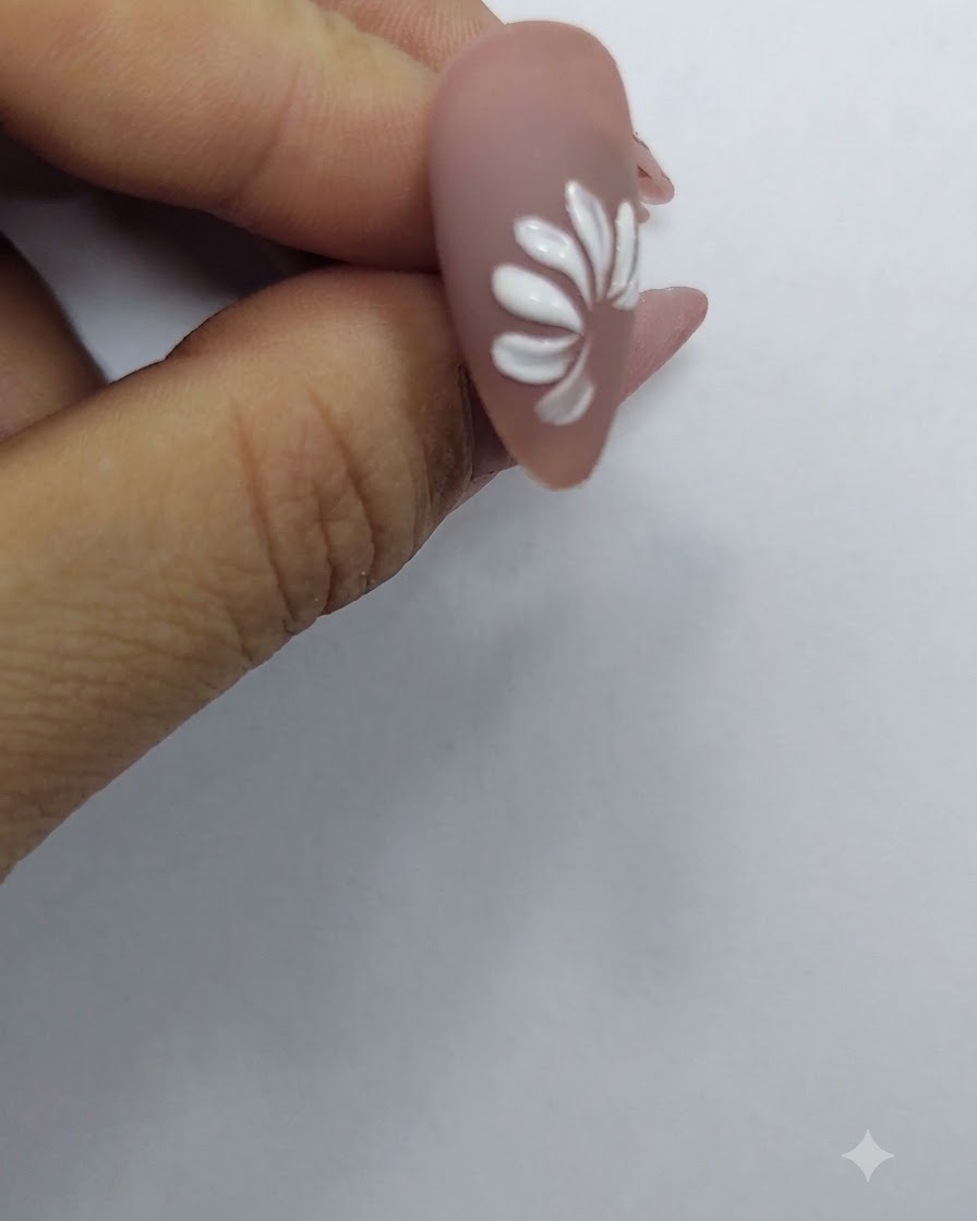 A completed ring of white petals forming a full daisy flower shape on a nude nail background.
