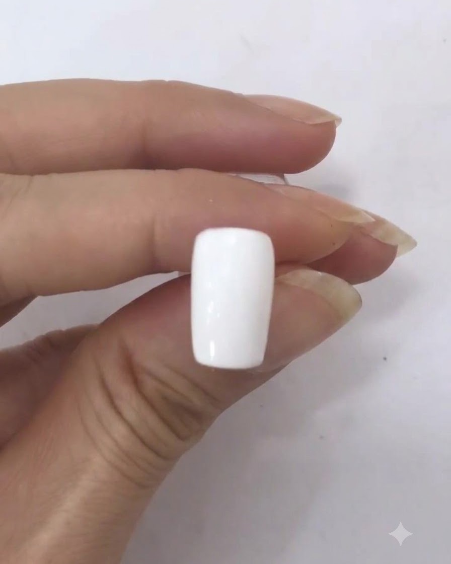 A single dark red dot sitting in the middle of a white nail surface.