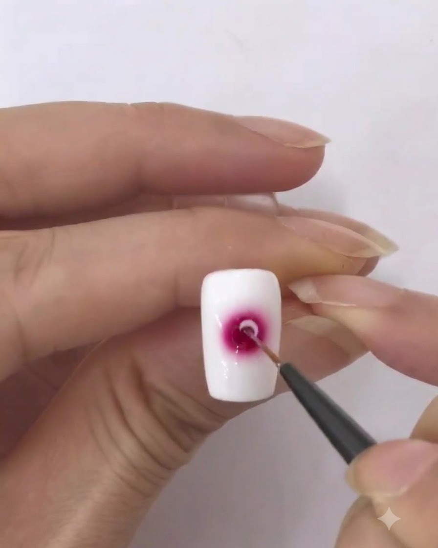 A fine liner brush loaded with a small amount of white gel polish.