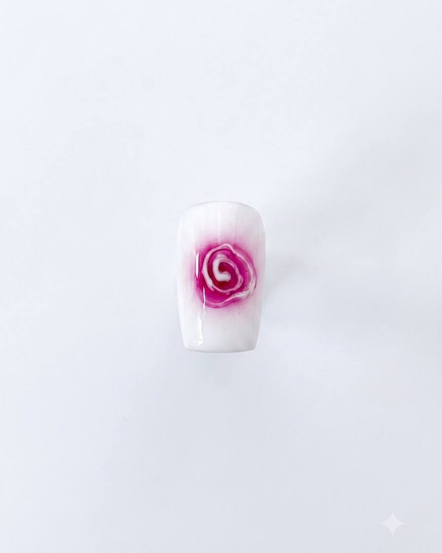 A completed blooming rose nail art design featuring a red center and soft white expanding petals on a white background.