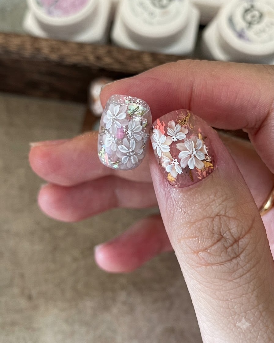 Applying a clear base coat over the cured blooming nail design.
