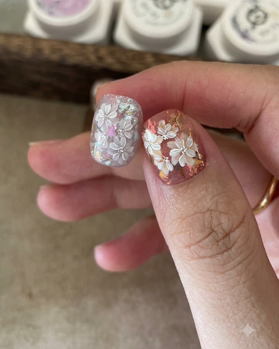 A brush applying a matte top coat over a hand-painted floral nail design.