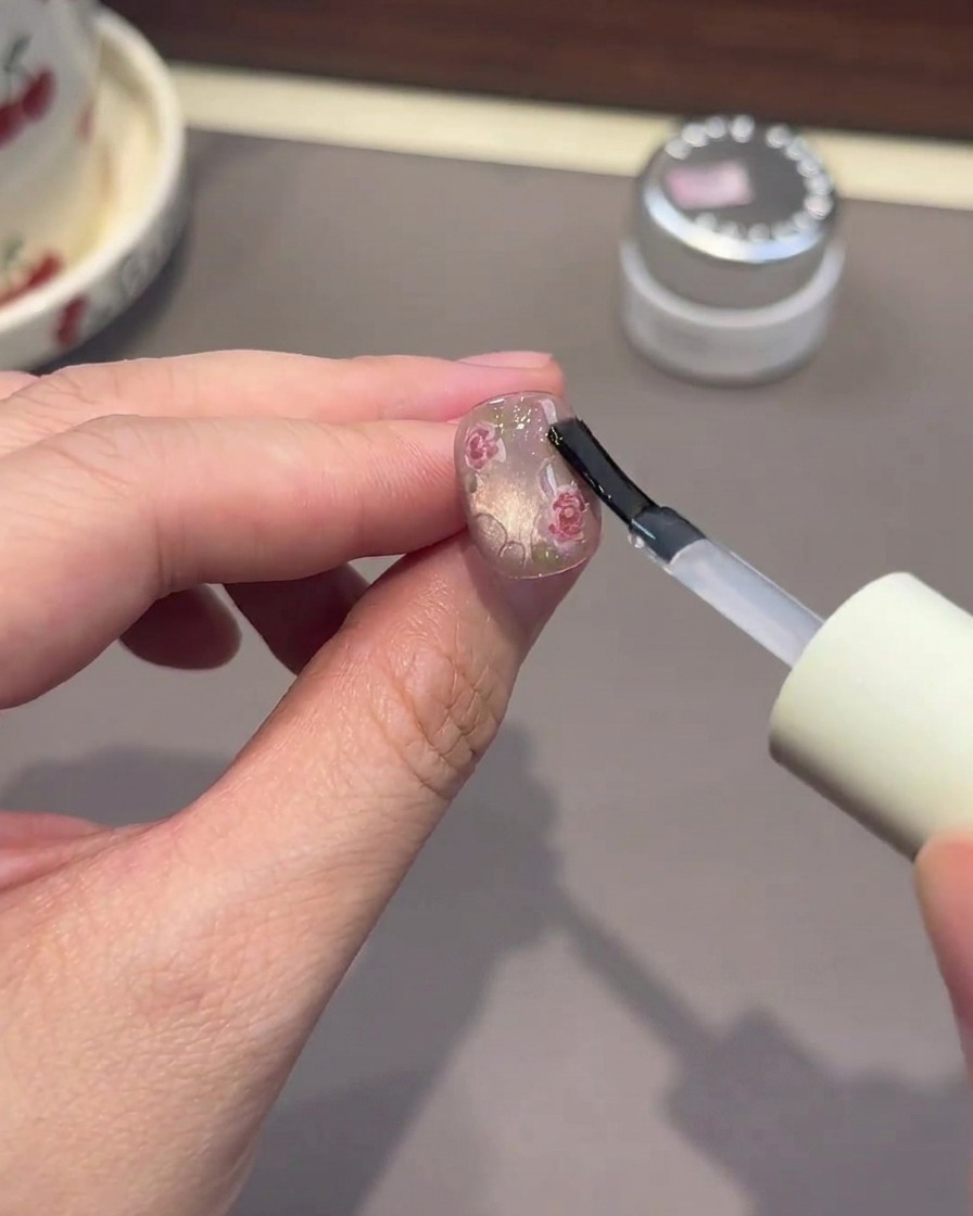 A brush applying thick clear gel to form water droplet effects on the nail.