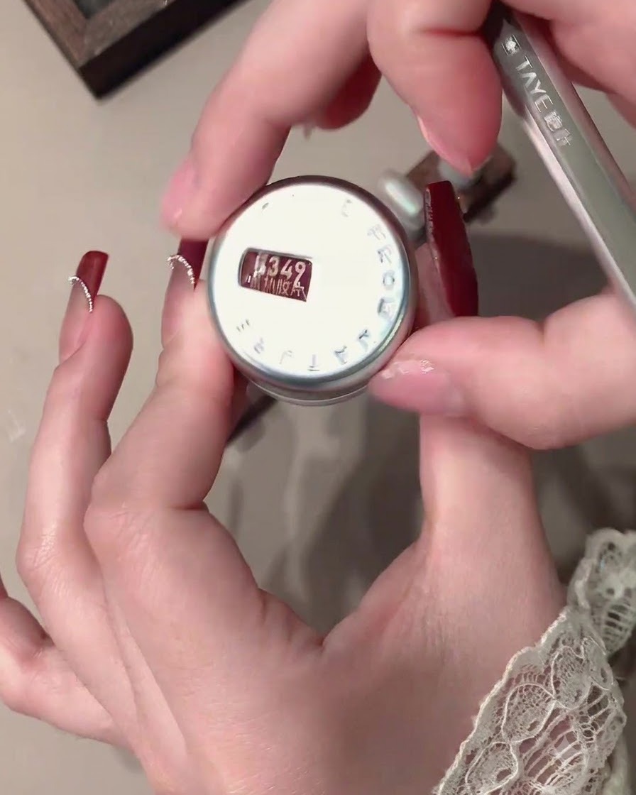 A magnet positioned near a red velvet nail to manipulate the light particles.