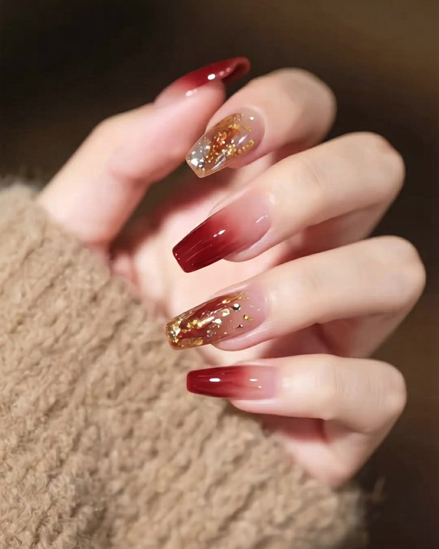 A close-up shot of a hand with detailed nail art, showcasing a prominent statement crystal and thin gold lines.